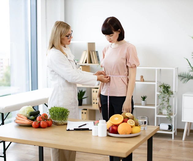 Nutritionist measuring woman’s waist