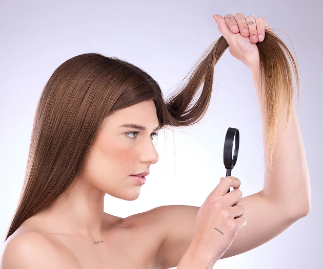 Woman examining hair