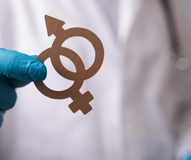 Doctor holding gender symbols