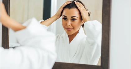 Woman in bathrobe looking mirror
